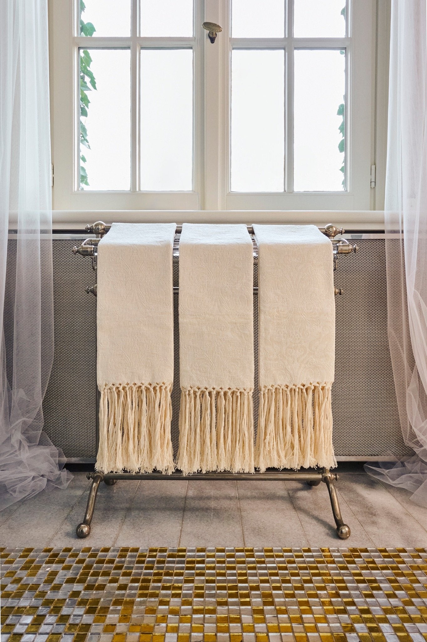 Set of luxury linen hand towels with hand-knotted fringe displayed in a classic bathroom interior. LA TRANQUILLINA