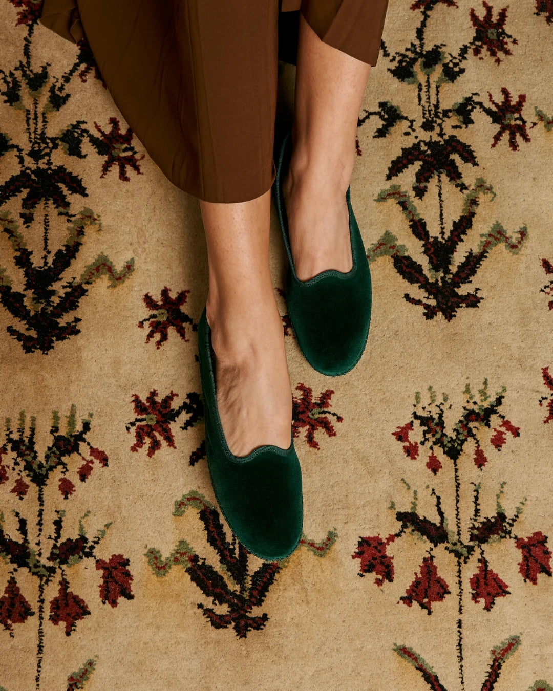 Green velvet Rialto friulane shoes by LA TRANQUILLINA worn on patterned carpet