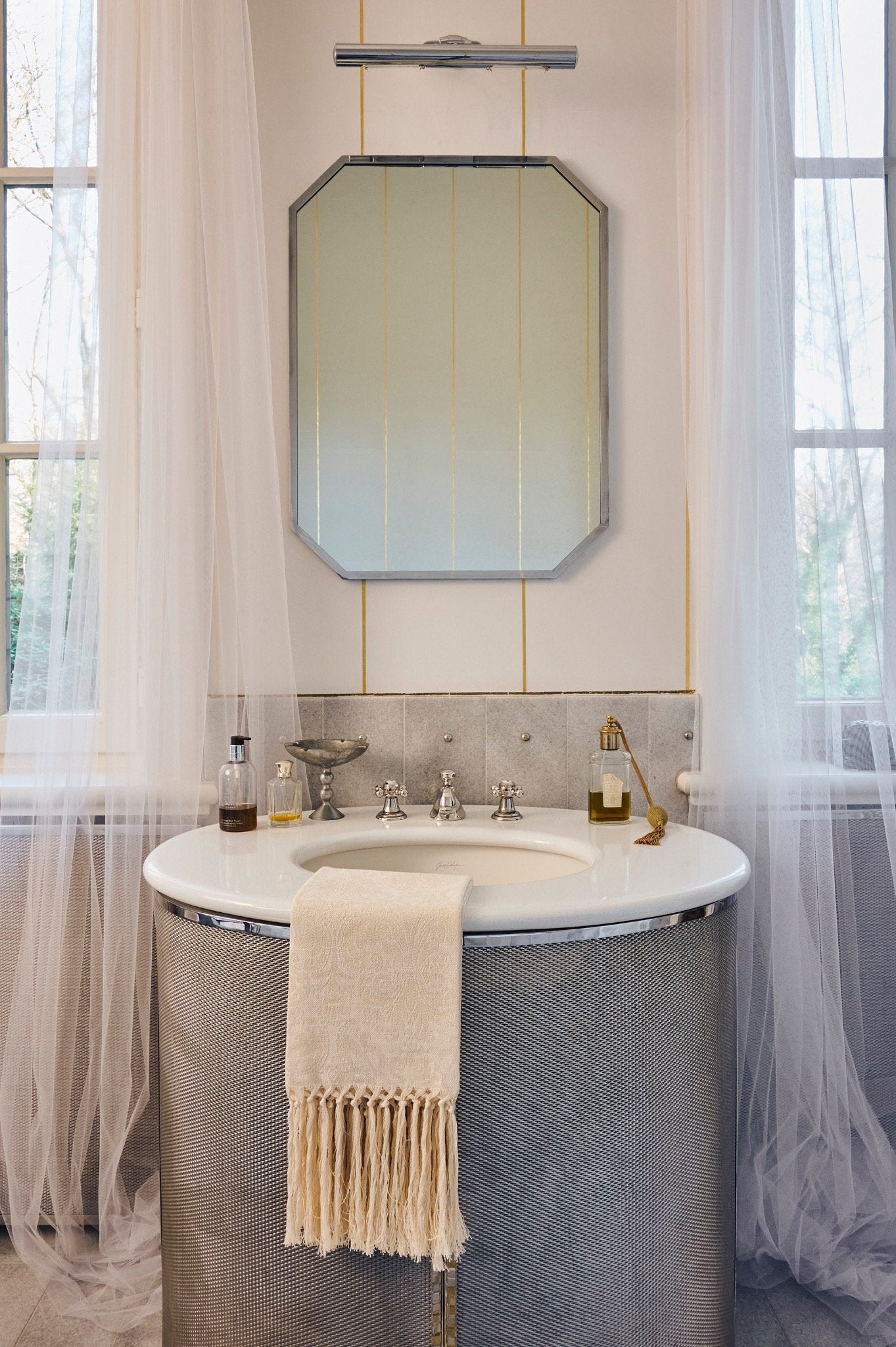 Luxury Italian linen hand towel with hand-knotted fringe displayed on a bathroom sink, by LA TRANQUILLINA