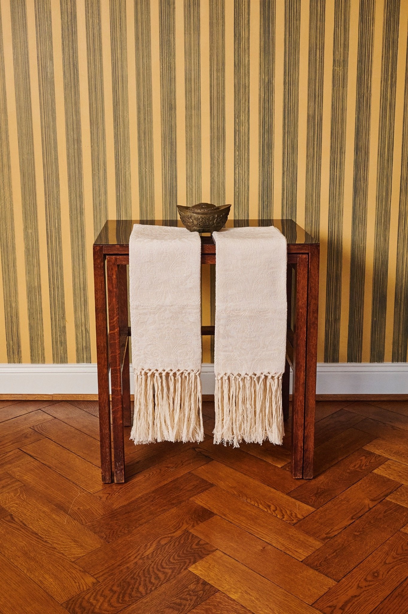 Luxury linen hand towels with hand-knotted fringe styled on a wooden console table